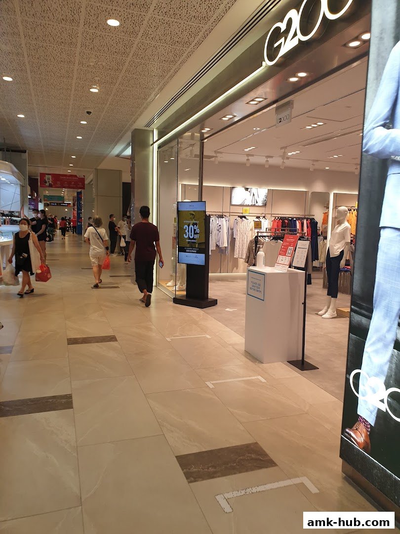 The G2000 store entrance with mannequins and clothing displays, and social distancing markers on the floor.