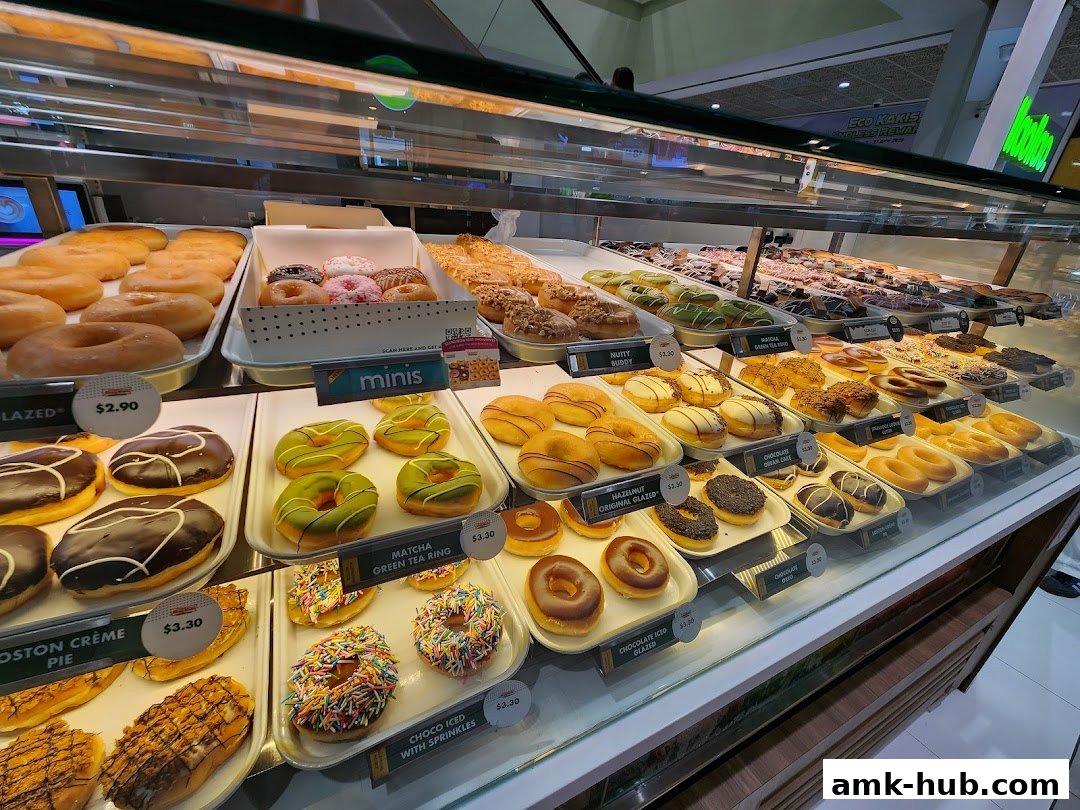 A display case filled with a variety of colorful and glazed donuts at Krispy Kreme.