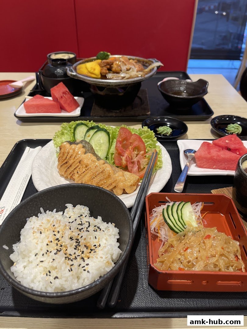 A delicious Japanese meal featuring grilled salmon, rice, and side dishes.