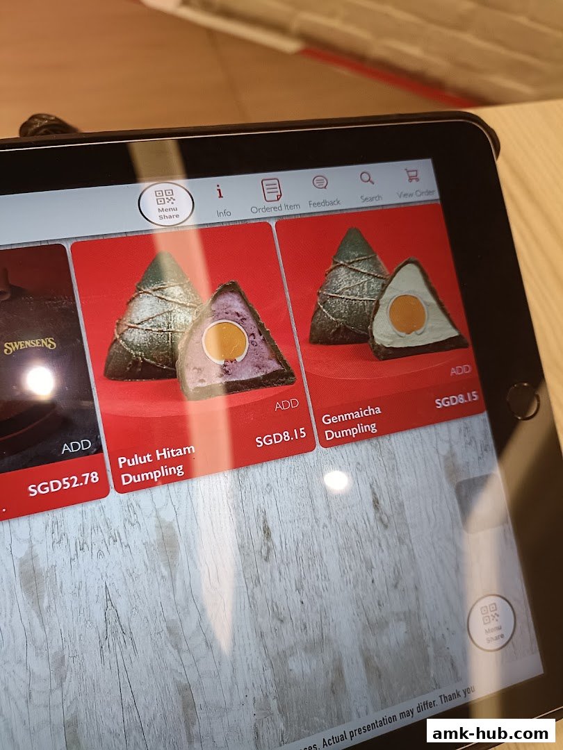 A tablet displaying a digital menu with various dumplings and prices.