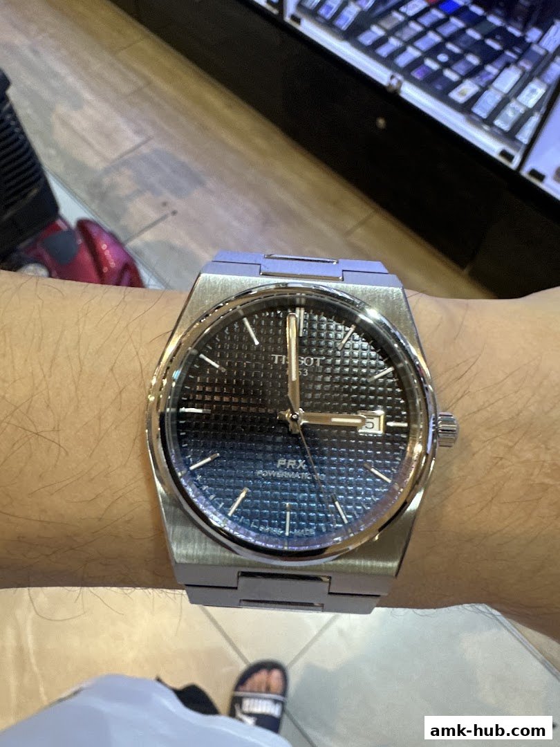 A close-up shot of a Tissot PRX Powermatic 80 watch on a person's wrist.