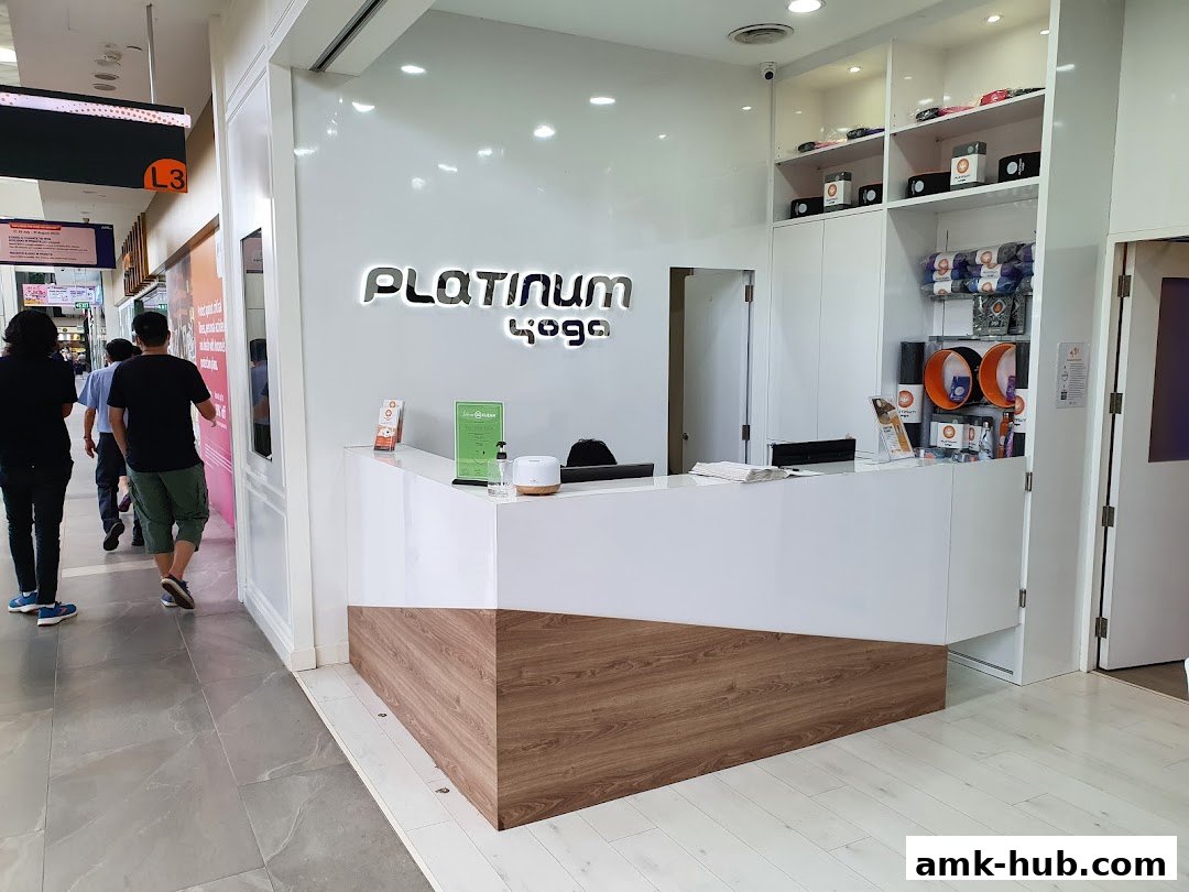 The reception area of Platinum Yoga Ang Mo Kio Hub with a white counter and shelves displaying yoga merchandise.