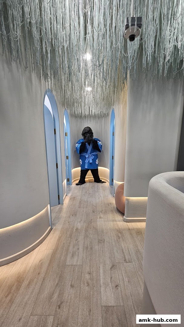 A hallway with a gorilla mascot in a kimono and decorative strings hanging from the ceiling.