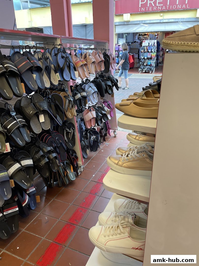 A Bata shoe store displays a wide variety of sandals and sneakers on shelves and racks.