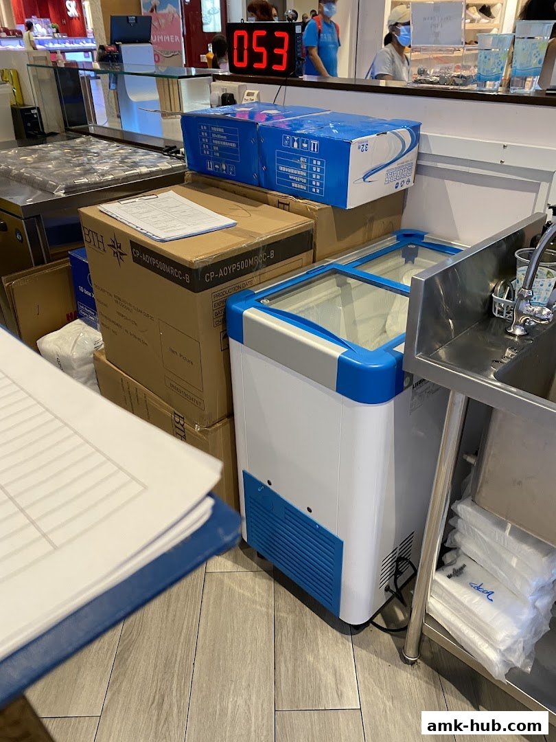 A counter area with boxes, a mini-fridge, and a sink at Mr. Coconut.