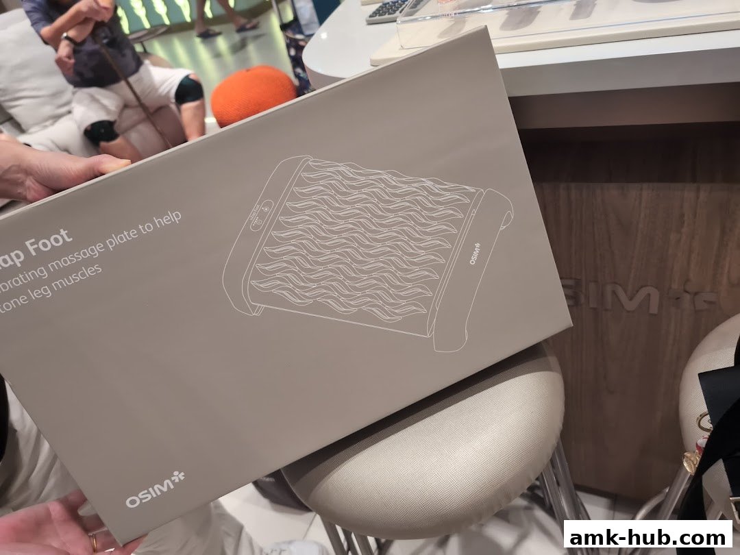 A person holds a box for an OSIM massage plate for foot and leg muscles.