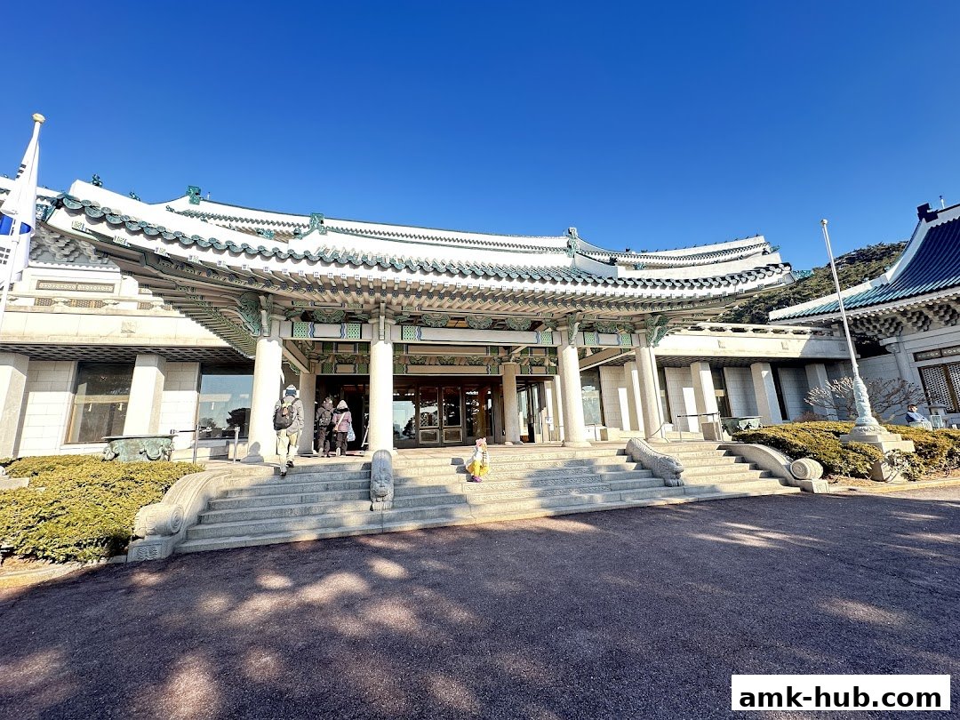 The entrance of a traditional building with ornate architecture and a clear blue sky.