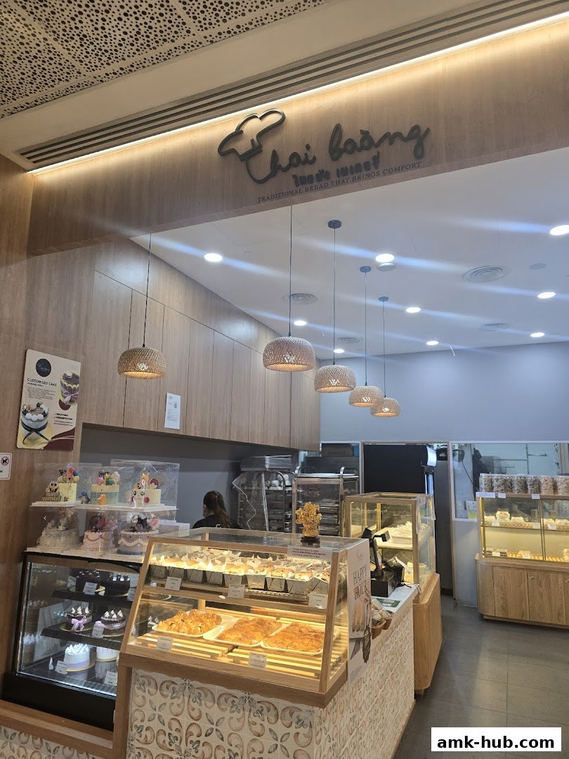 Interior view of a bakery with display cases filled with cakes and bread.