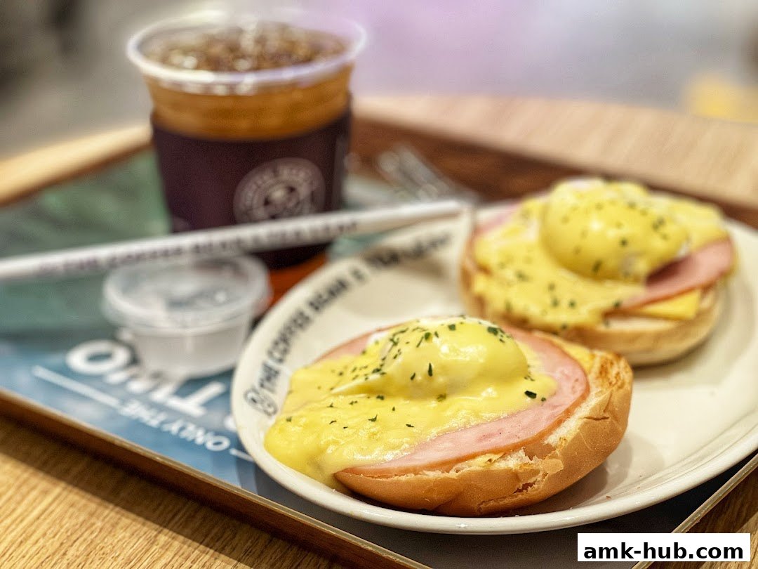 A delicious breakfast spread featuring Eggs Benedict and iced coffee on a tray.