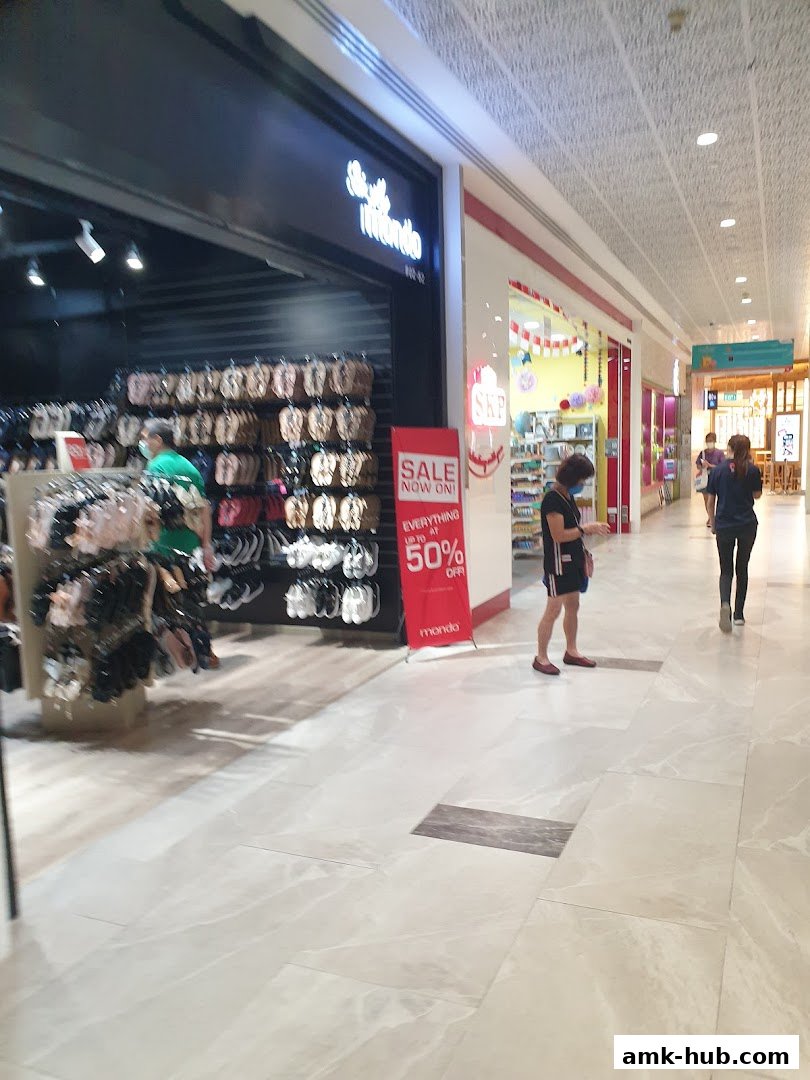 A retail shop with a display of footwear and a sale sign outside.