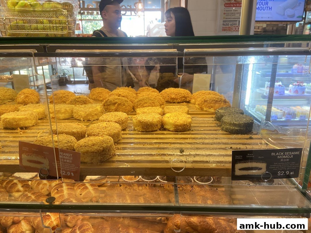 A display case filled with various baked goods, including round cakes and bread, at BreadTalk.