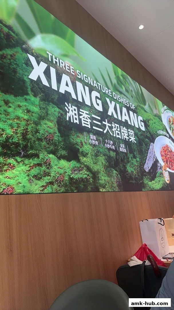A large sign displays "THREE SIGNATURE DISHES OF XIANG XIANG" with images of food.