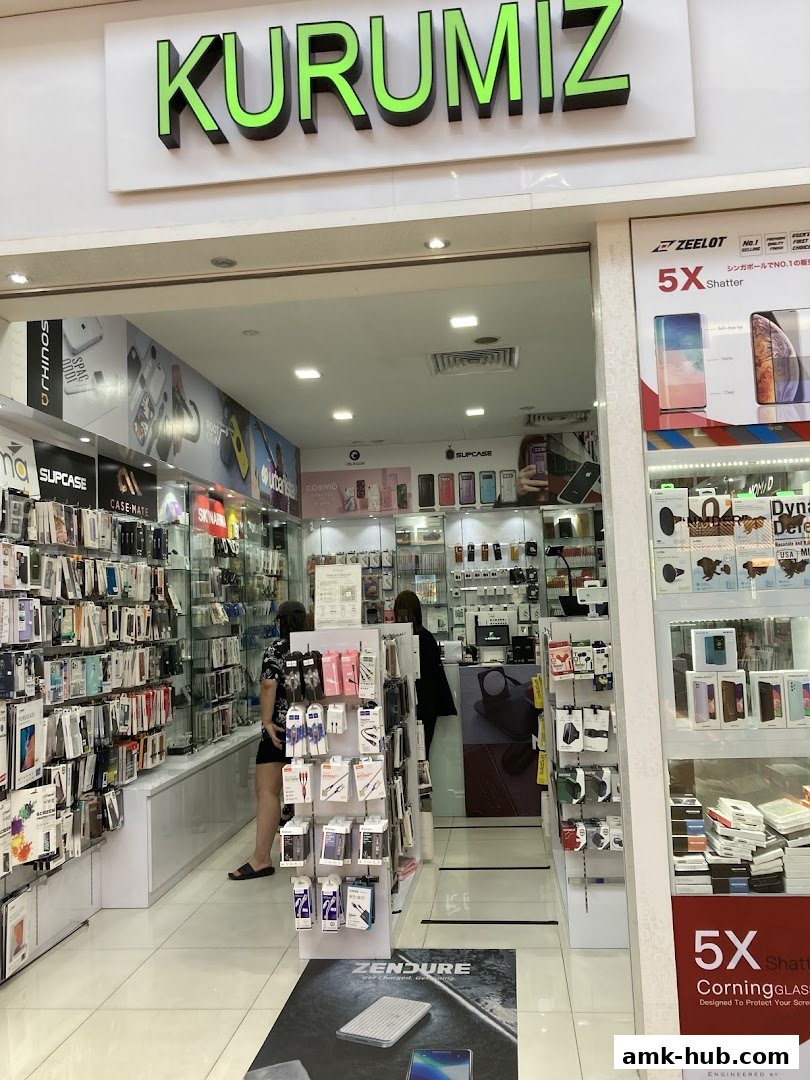 The entrance of a shop called KURUMIZ, filled with phone accessories and displays.