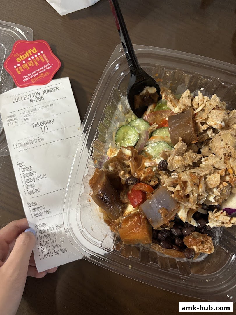 A takeaway chicken bowl with various ingredients and a receipt from Stuff'd.