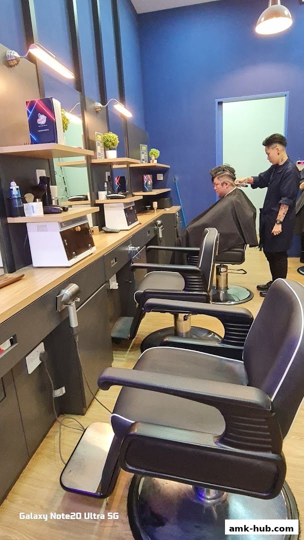 Barber giving a haircut to a customer in a modern barber shop with multiple chairs.