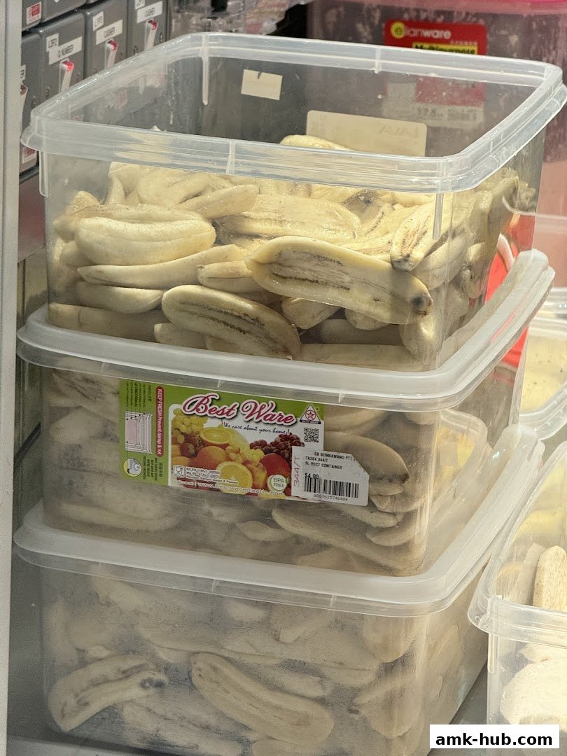 Stacked plastic containers filled with sliced bananas, likely for sale.
