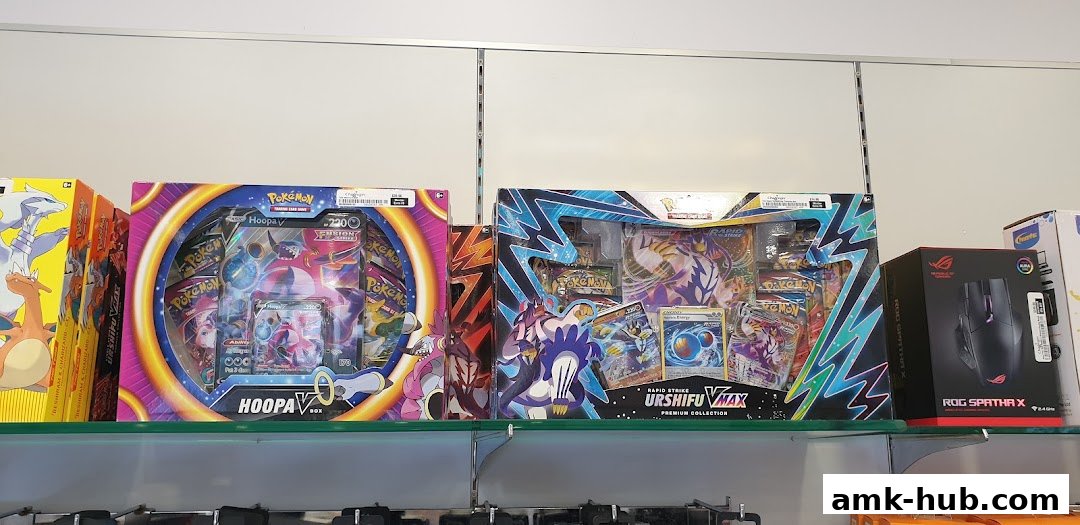 Pokemon trading card game boxes and a gaming mouse are displayed on shelves.