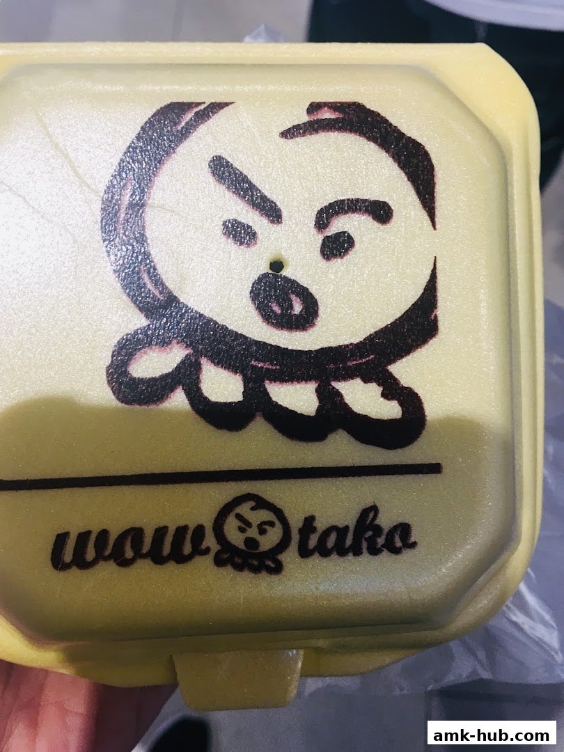 A yellow food container with the "Wow Tako" logo and a cartoon character.