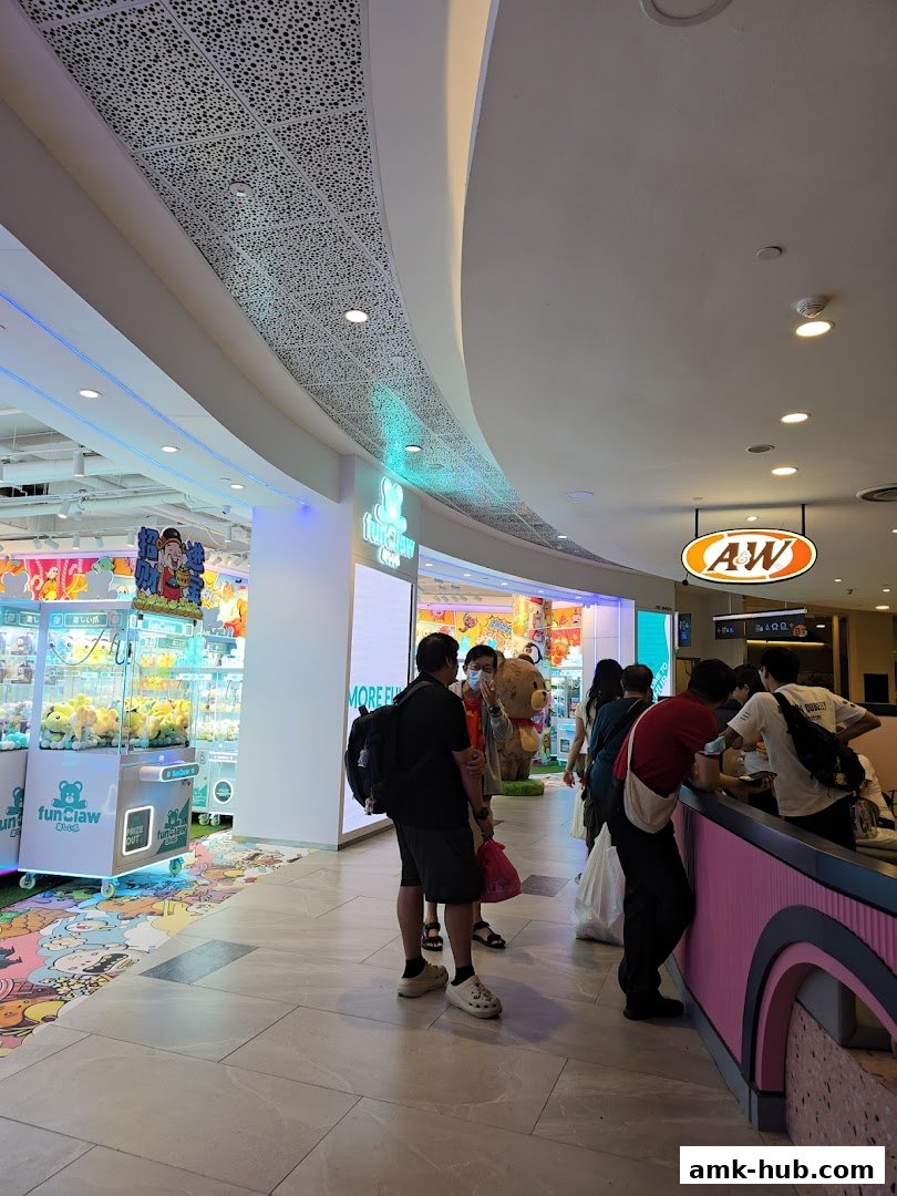 People are queuing at a counter in a mall, with shops like Fun Claw and A&W visible.
