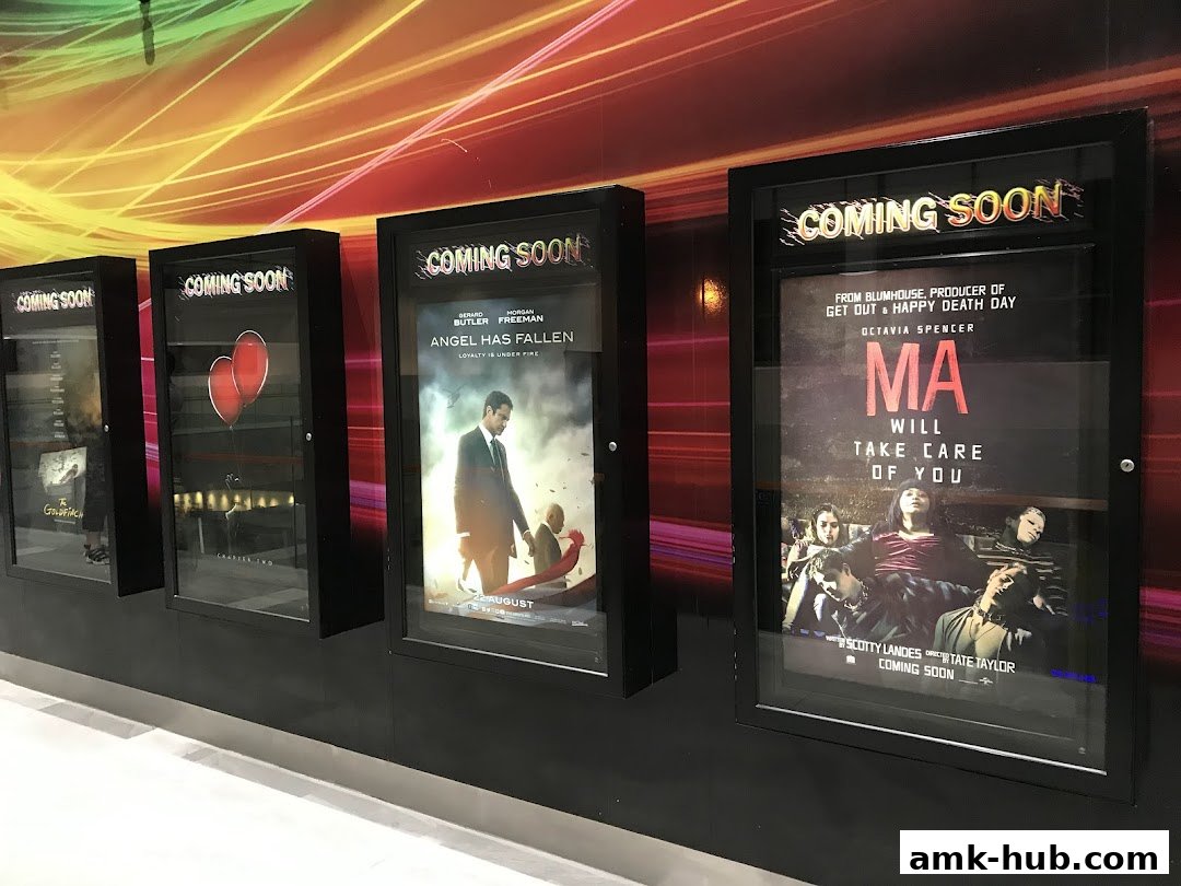 Movie posters displayed in a cinema lobby, advertising upcoming films.