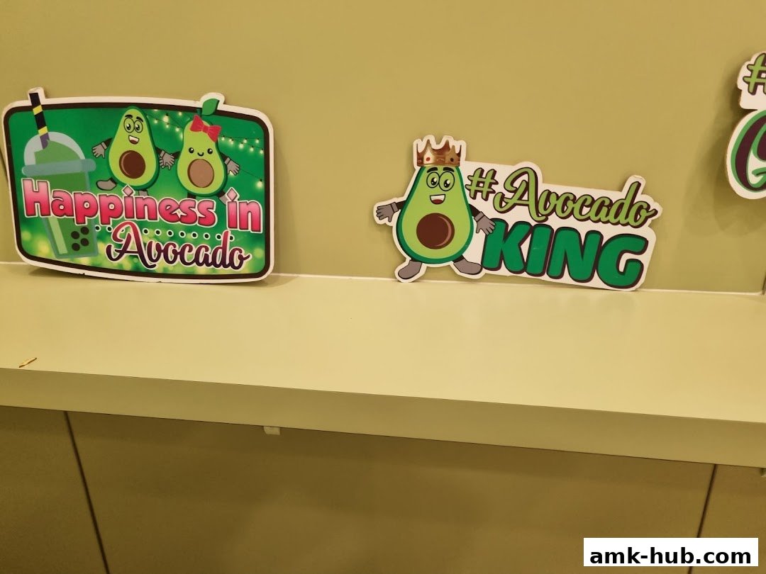 Decorative signs featuring cartoon avocados with slogans like 'Happiness in Avocado' and '#Avocado KING'.