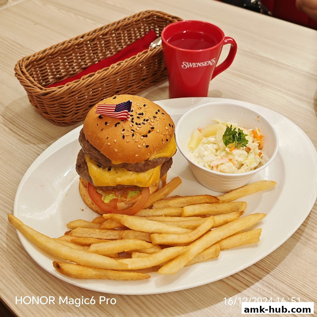A double cheeseburger with fries and coleslaw, served with a drink in a Swensen's mug.