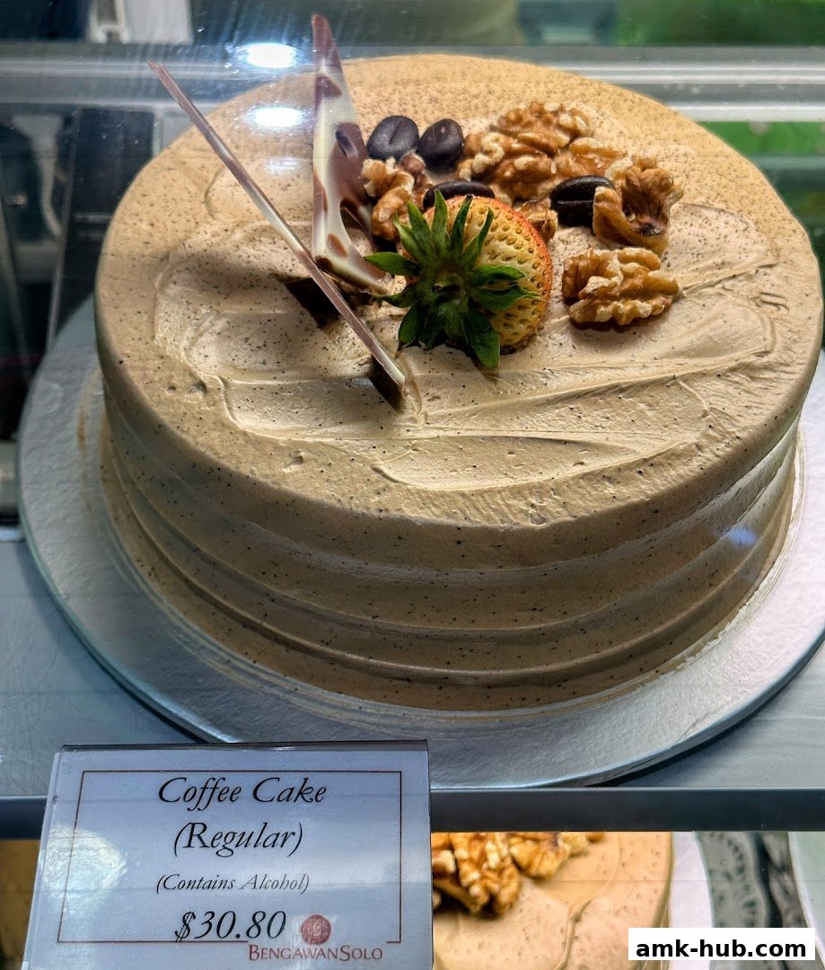 A delicious coffee cake topped with walnuts, coffee beans, and a strawberry.