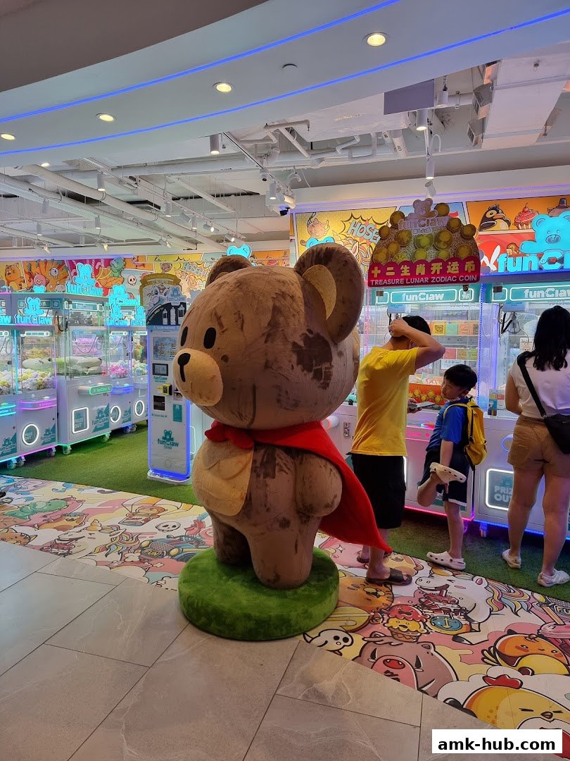A large teddy bear statue stands in front of claw machines at Fun Claw.