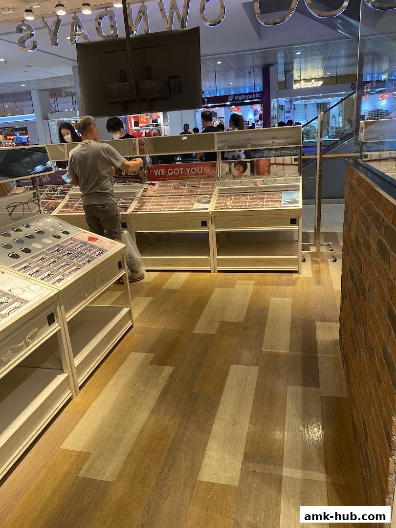 An optical shop interior with displays of eyeglasses and customers browsing.