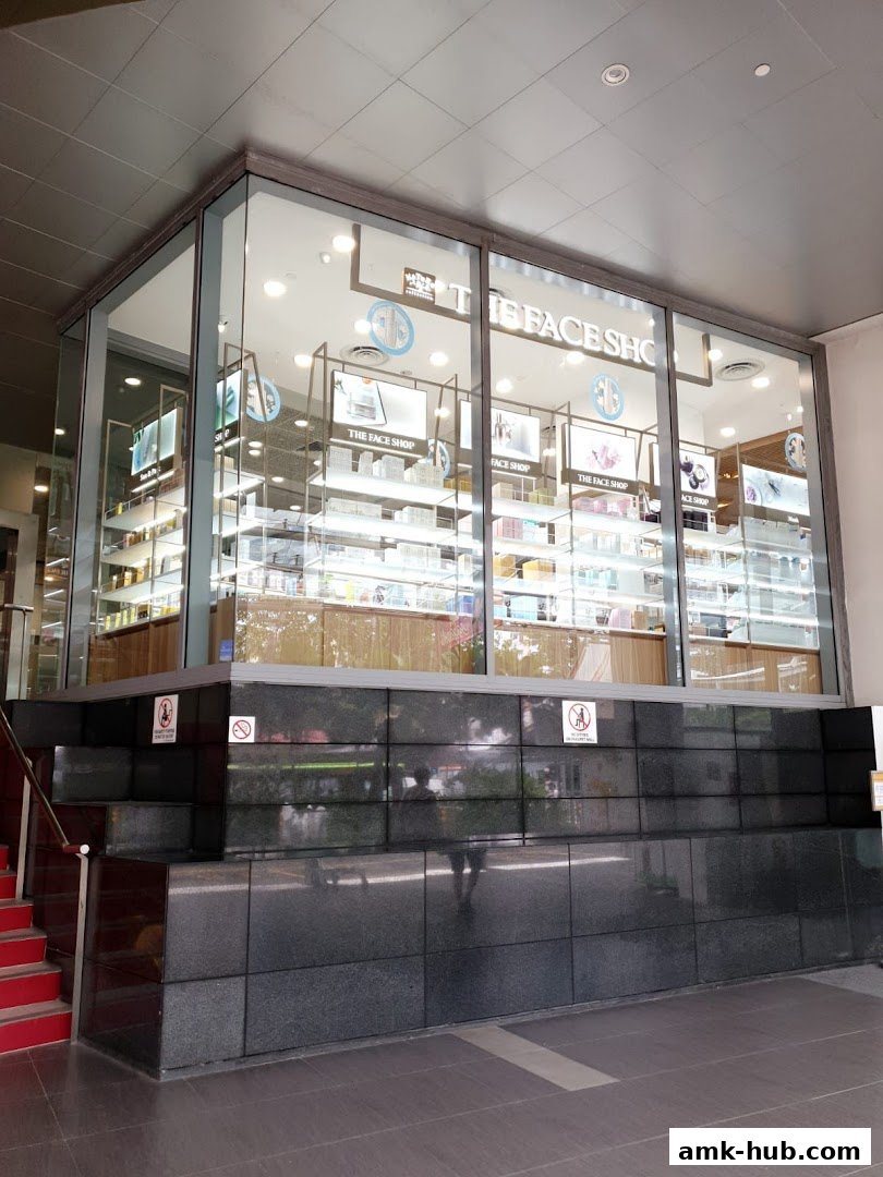 The exterior of The Face Shop, a beauty store, showcasing its products through a large glass window.