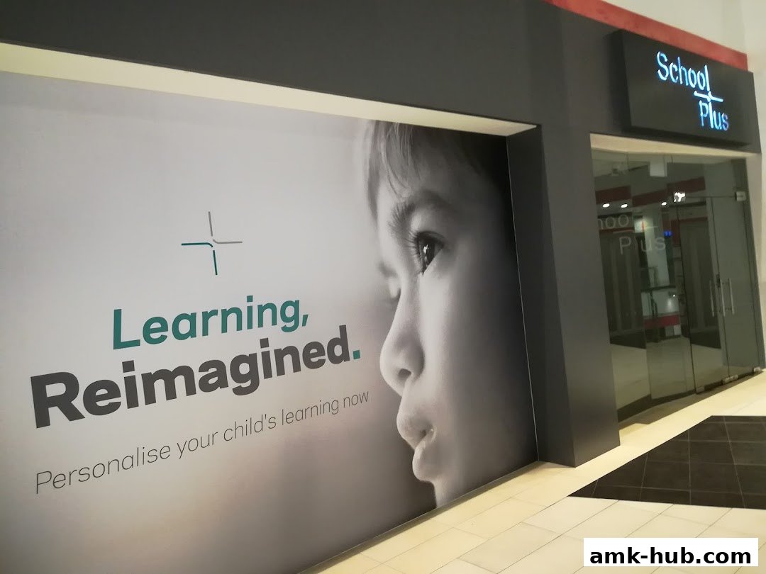 The exterior of the School Plus shop with a large graphic of a child's face and text.