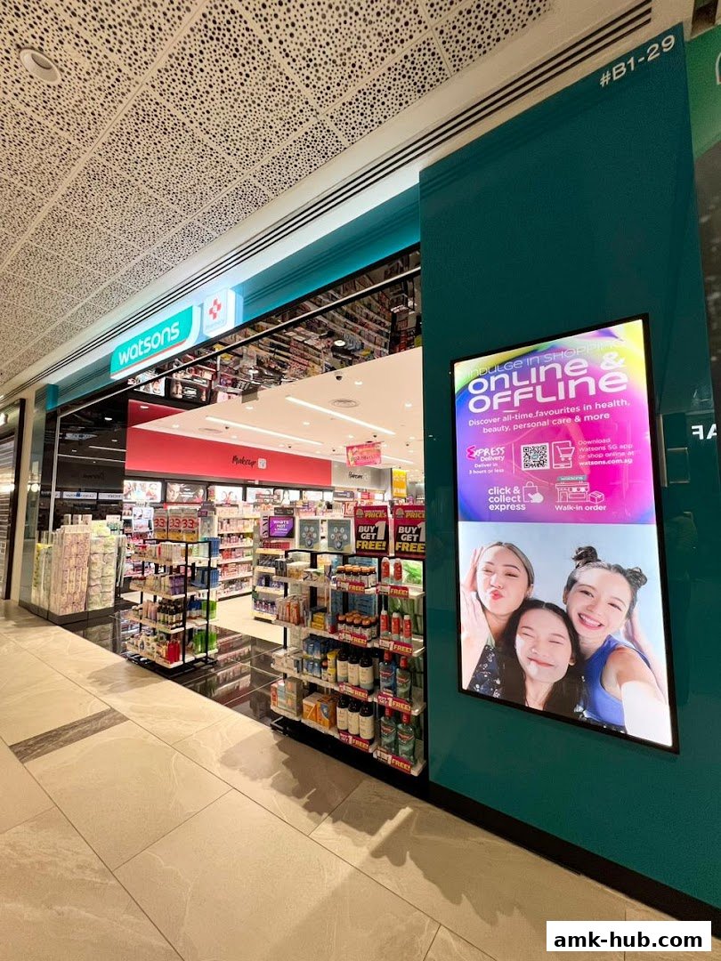 The exterior of a Watsons store, showcasing health and beauty products and a digital display.