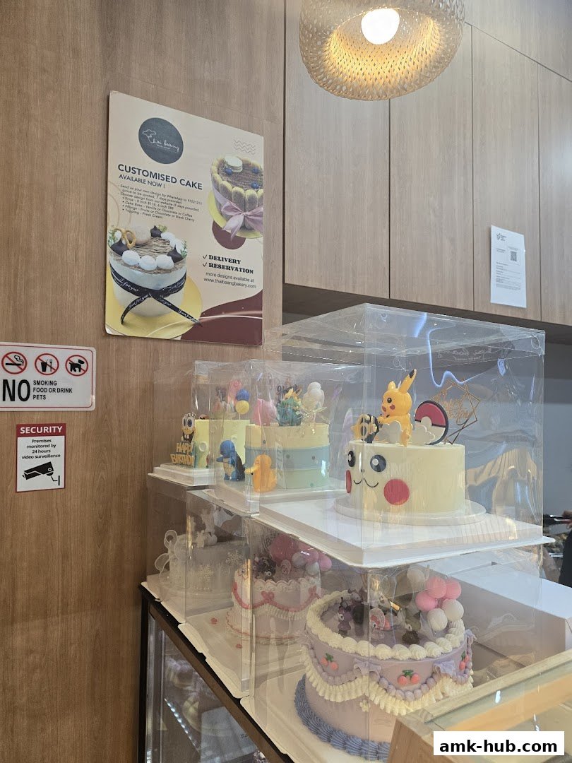 A display of beautifully decorated custom cakes, including themed cakes like Pokemon, in a bakery.