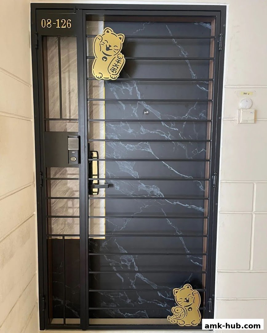 A modern black metal gate with a marble pattern and lucky cat decals.