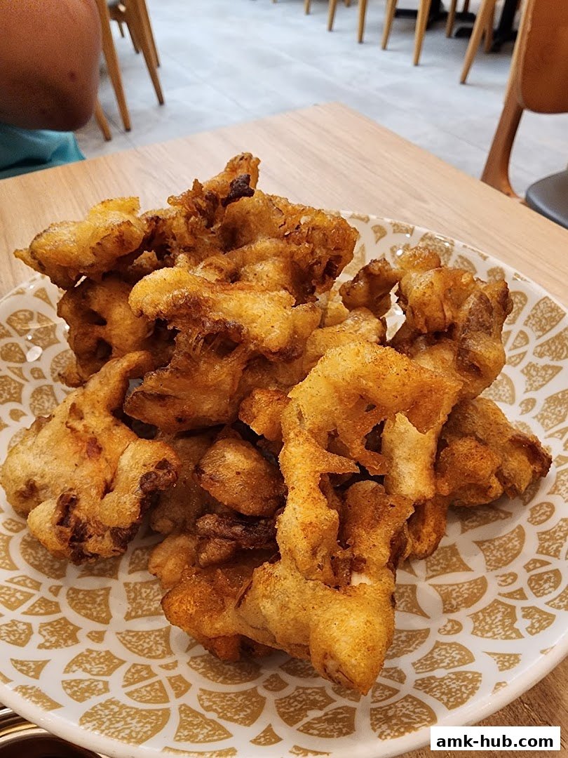 A close-up shot of a plate filled with crispy, golden-brown fried chicken pieces.
