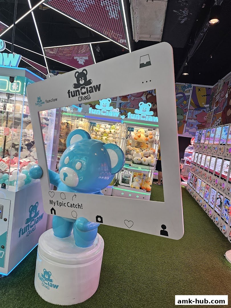 Interior of a claw machine arcade with plush toys and a large blue bear mascot.