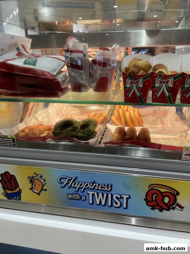 A display case filled with various pretzels and baked goods, with festive packaging.