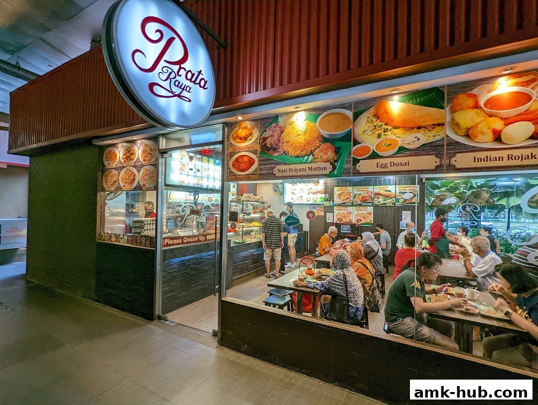 A busy Indian restaurant with customers dining and a prominent "Prata Raya" sign.
