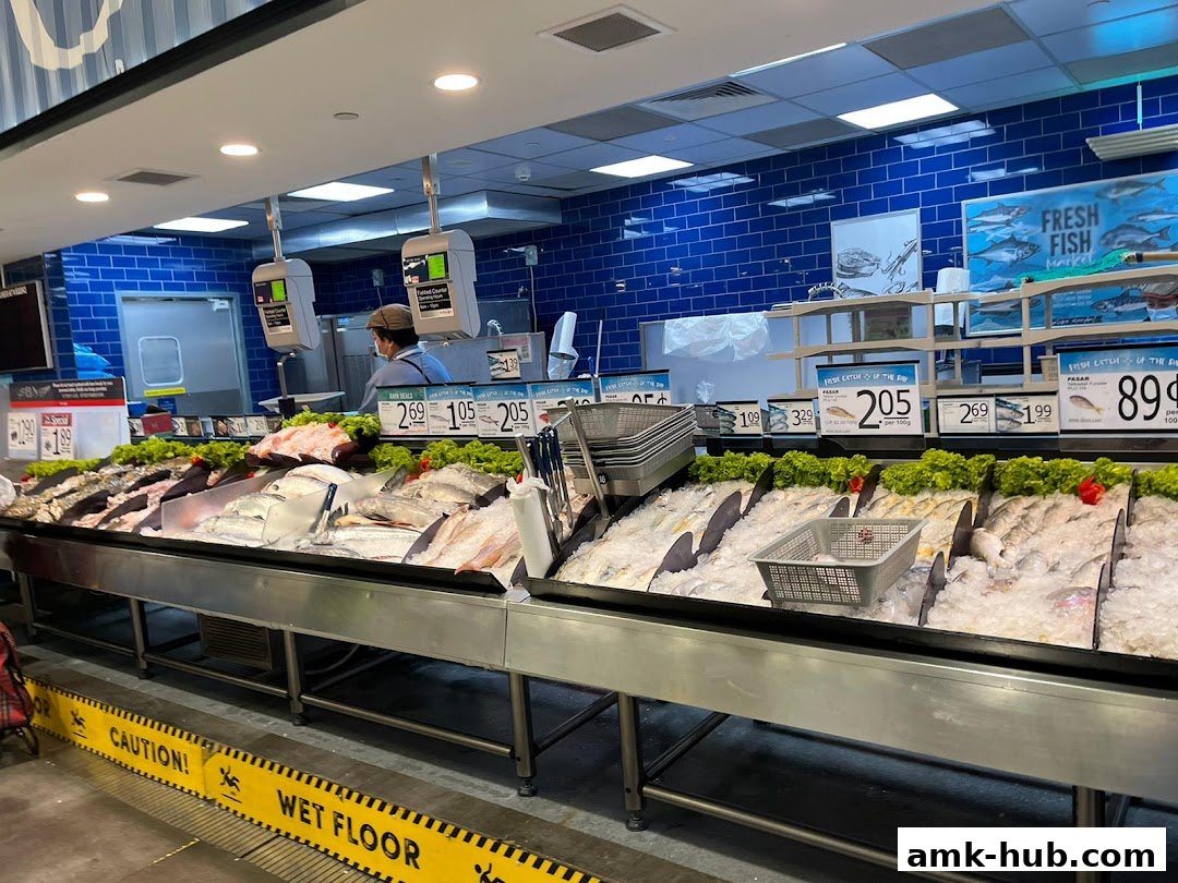 A display of fresh fish on ice at a supermarket counter with price tags.