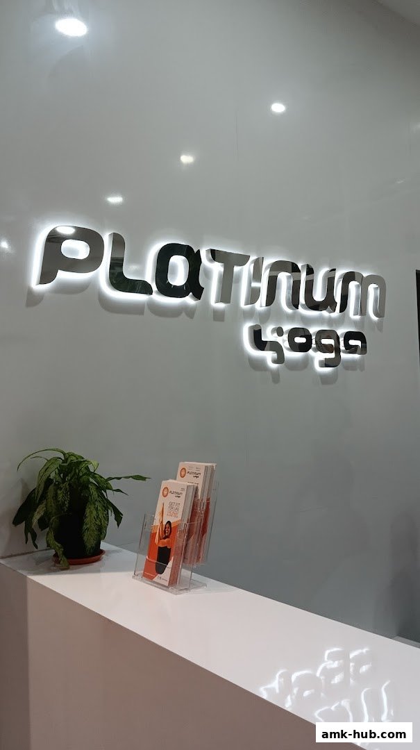 The reception area of Platinum Yoga Ang Mo Kio Hub with its illuminated logo and brochures.