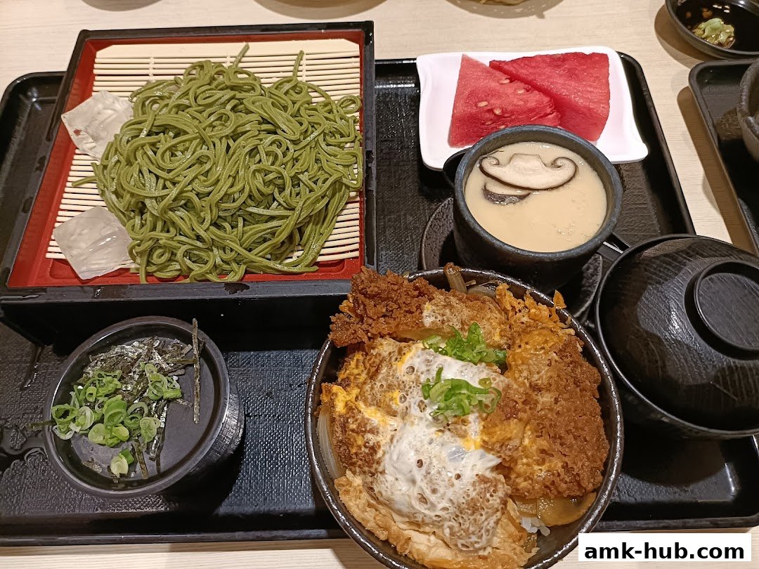 A delicious Japanese meal featuring soba noodles, katsudon, chawanmushi, and watermelon.
