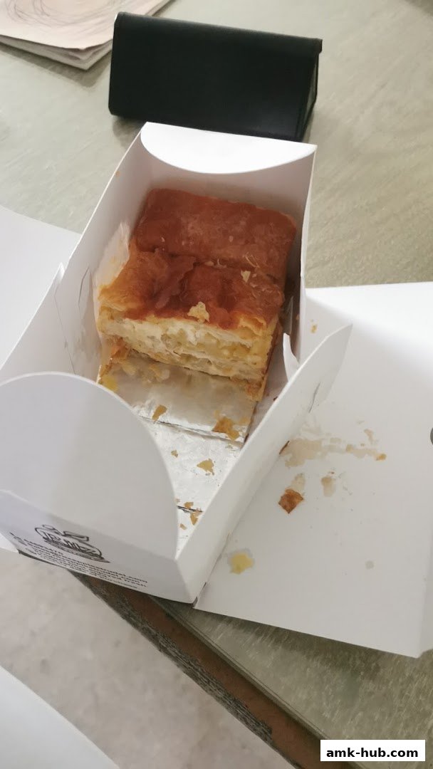 A delicious apple strudel pastry served in a white branded box.