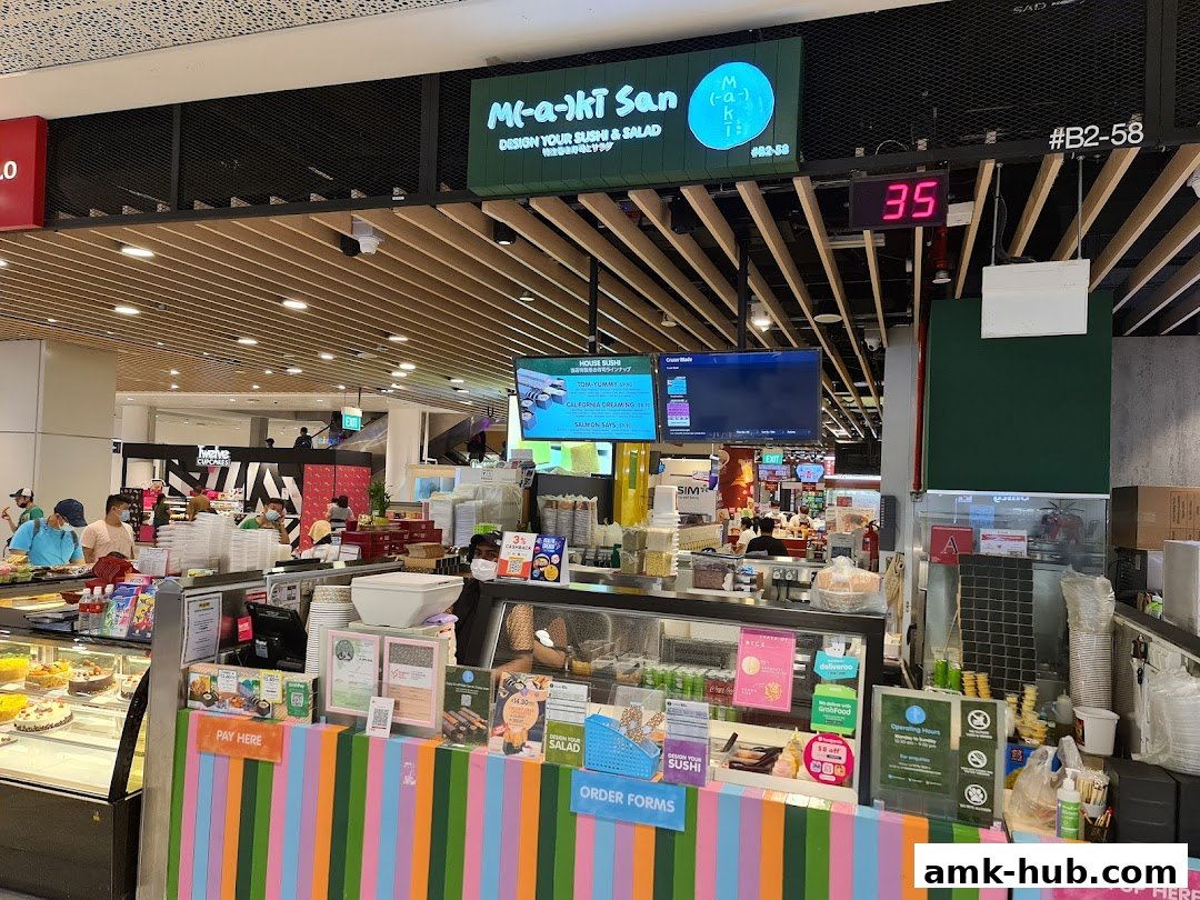 The Maki-San shop front with colorful stripes, displaying sushi and salad options.