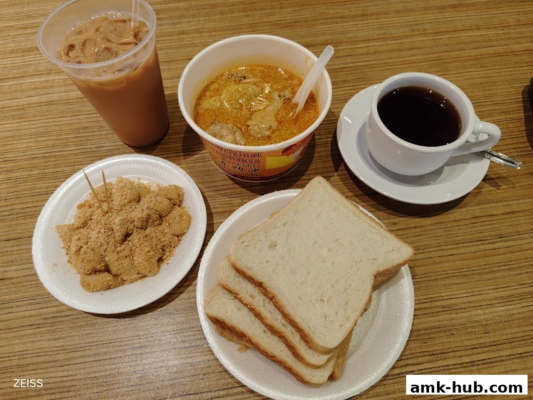 A spread of Janggut Laksa food items including laksa, toast, mochi, and drinks.