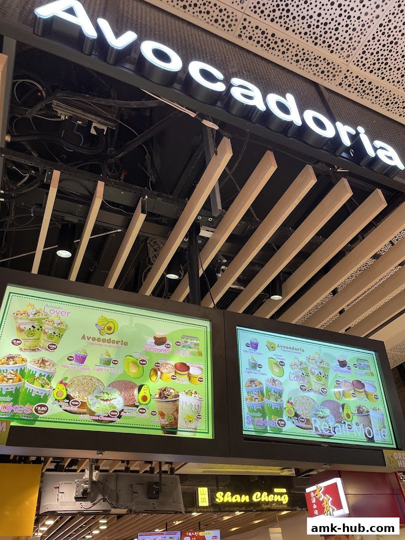 Digital menu boards displaying various avocado-based drinks and desserts at Avocadoria.