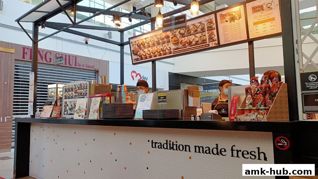 A Heavenly Wang food stall with staff serving customers and a menu board overhead.