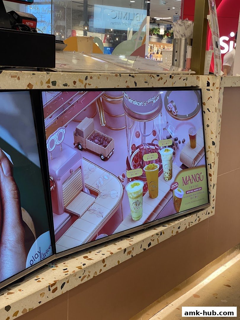 Digital display showcasing colorful drinks and a playful manufacturing theme.