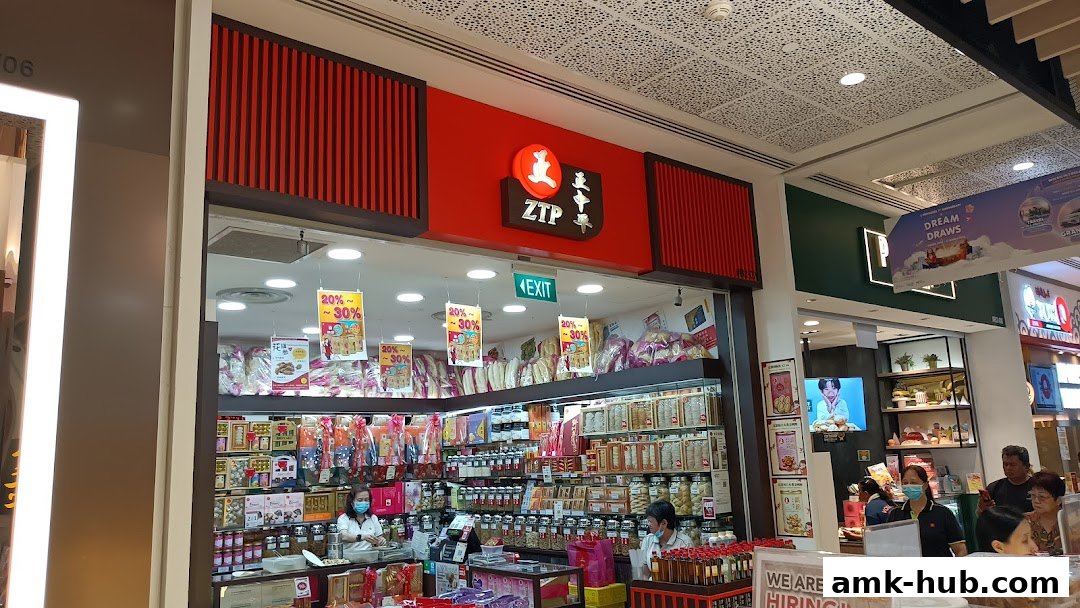 The ZTP shop front displays a wide variety of products with sale signs and staff serving customers.