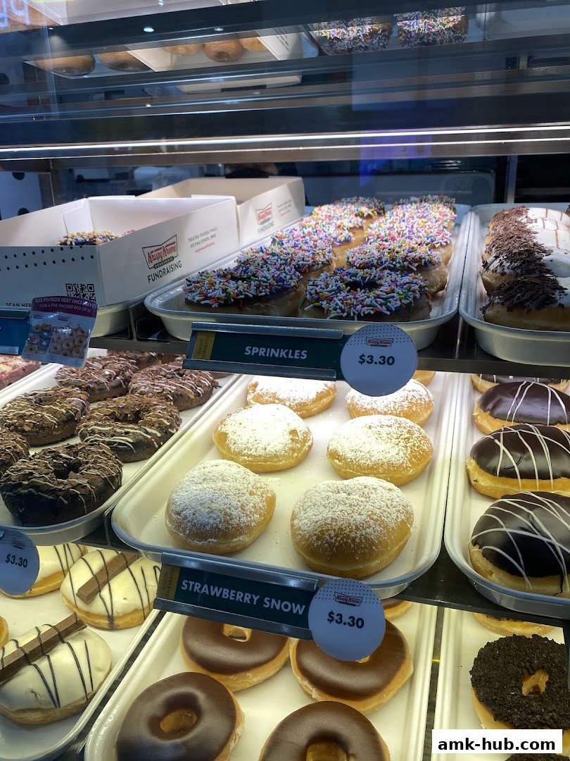 A display case filled with various colorful and delicious Krispy Kreme donuts.