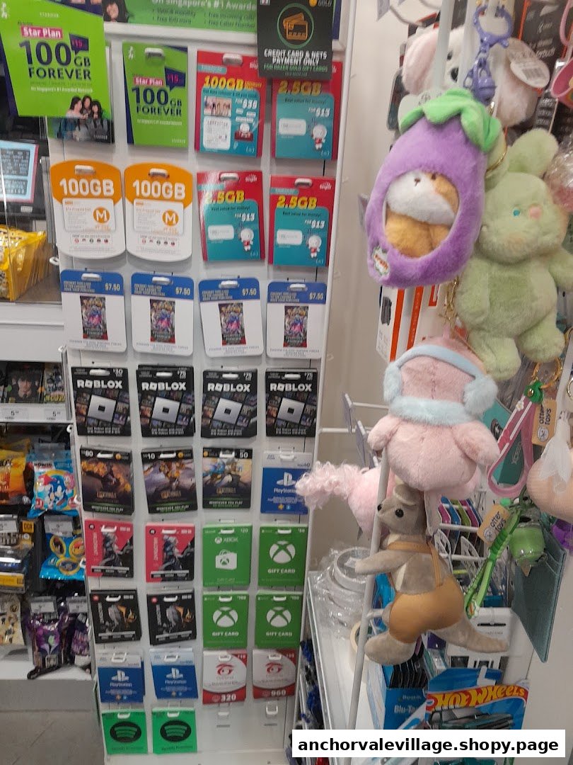 A retail display inside 7-Eleven showcasing various gift cards, mobile data plans, and plush toys.